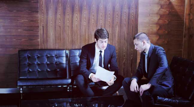 Business professionals reviewing confidentiality agreements and non-disclosure documents to protect beverage trade secrets and legal IP